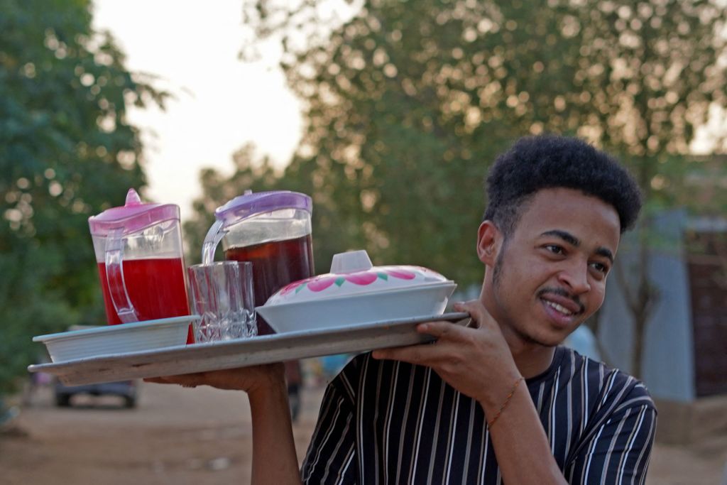 شاب سوداني يحمل صينية عصائر رمضان