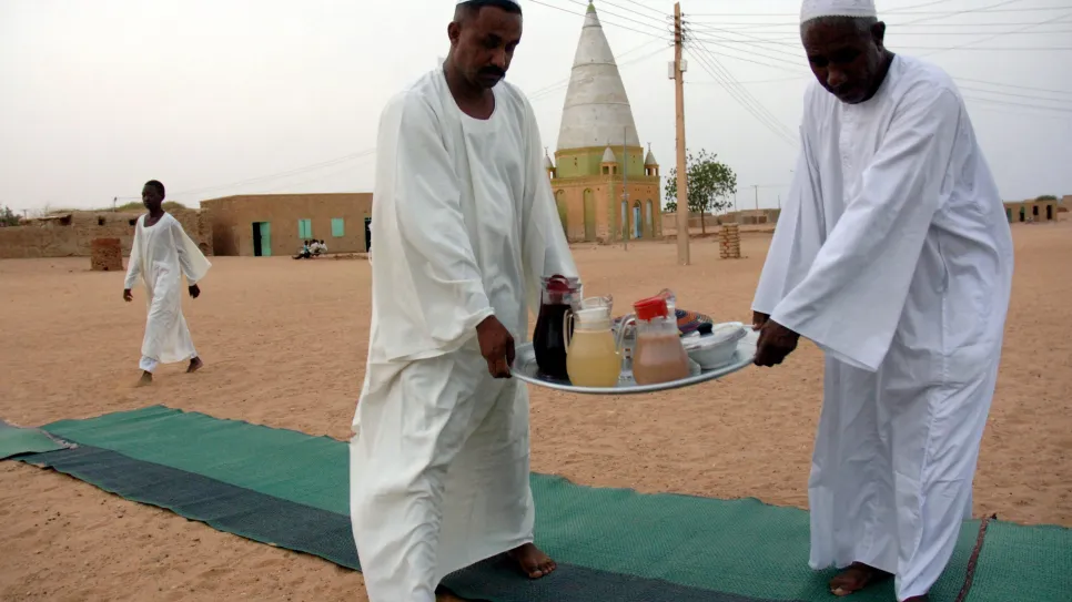 سودانيون يحملون صينية الفطور للمشاركة في إفطارات الشوارع.jpg