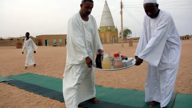 سودانيون يحملون صينية الفطور للمشاركة في إفطارات الشوارع.jpg